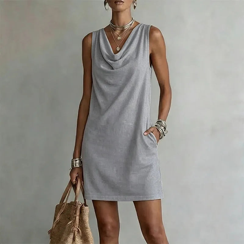 Woman wearing sleeveless mini dress with draped neckline