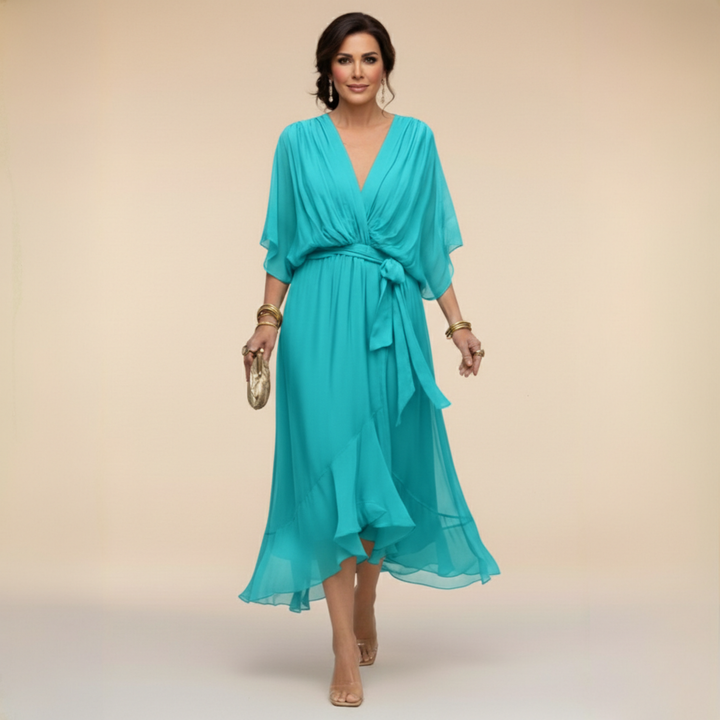 Woman wearing flowing V-neck dress in studio setting