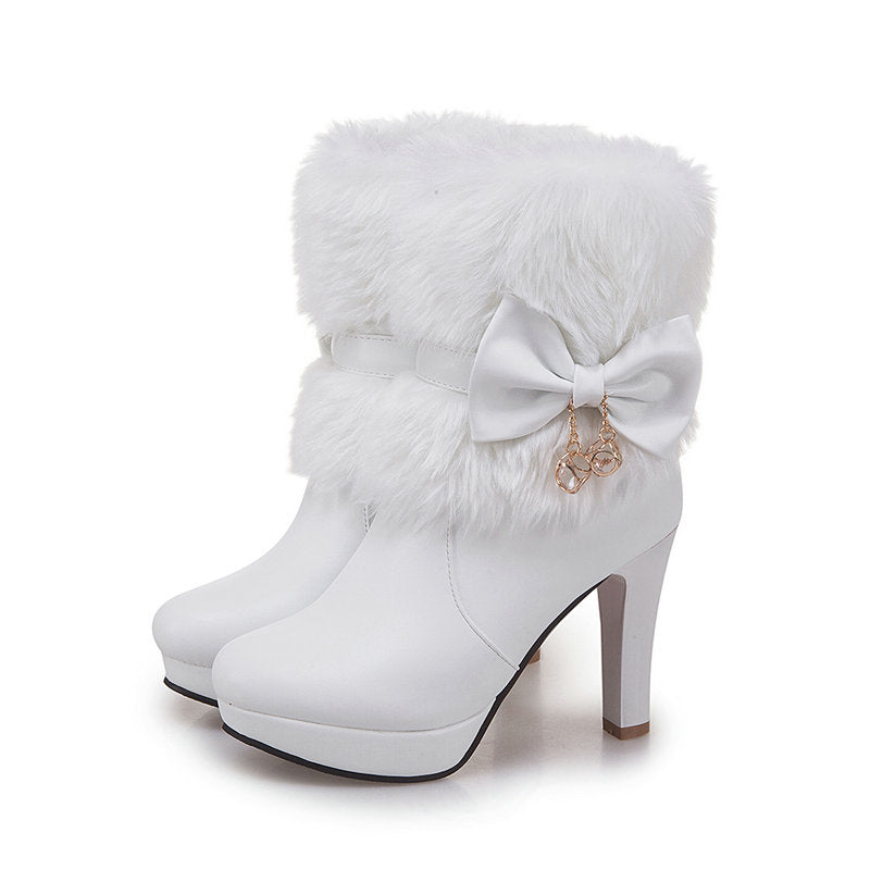 Woman wearing pink fur trim ankle boots with bow detail