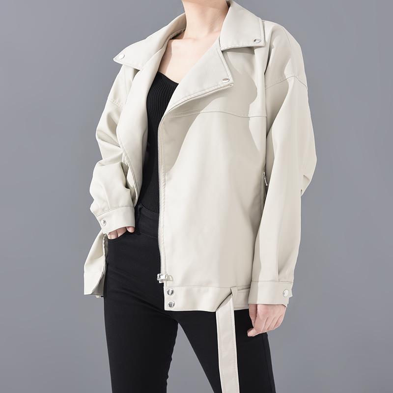Woman wearing motorcycle jacket with belt and lapel collar