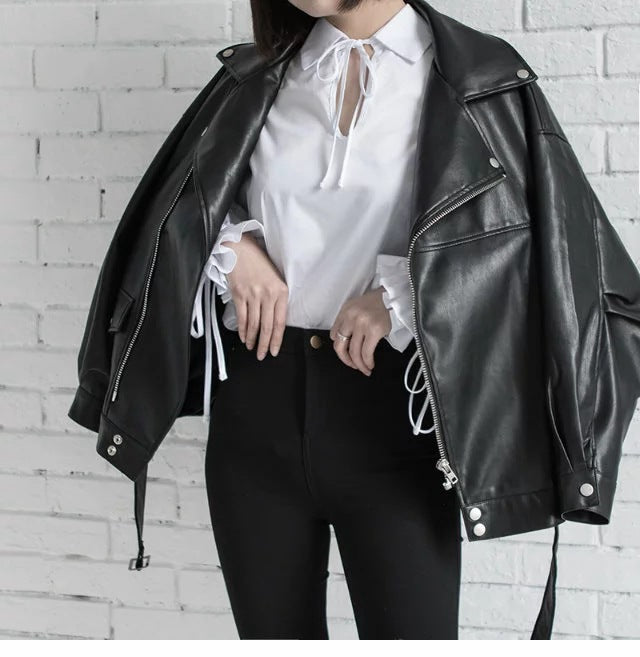 Woman wearing motorcycle jacket with belt and lapel collar