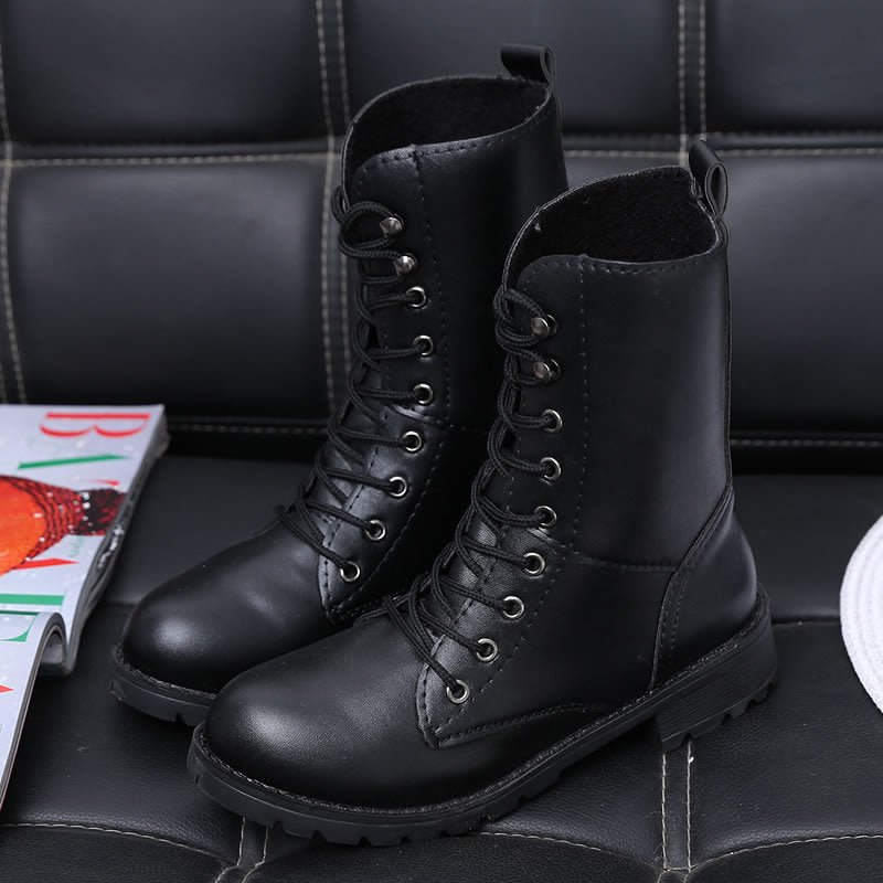 Woman wearing black lace-up combat boots with rivet details