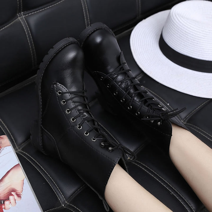 Woman wearing black lace-up combat boots with rivet details