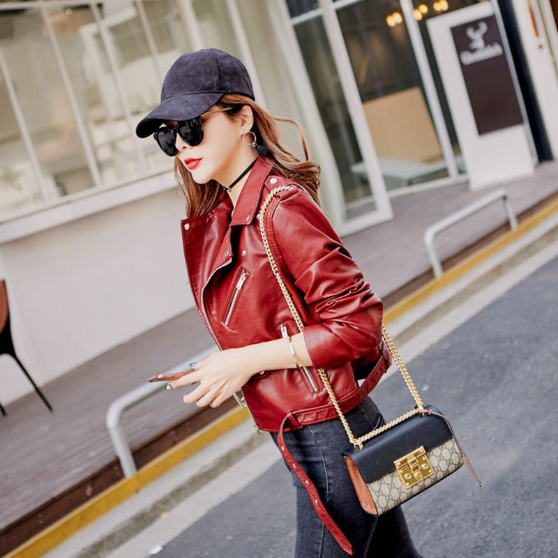 Woman wearing blue faux leather moto jacket with belt