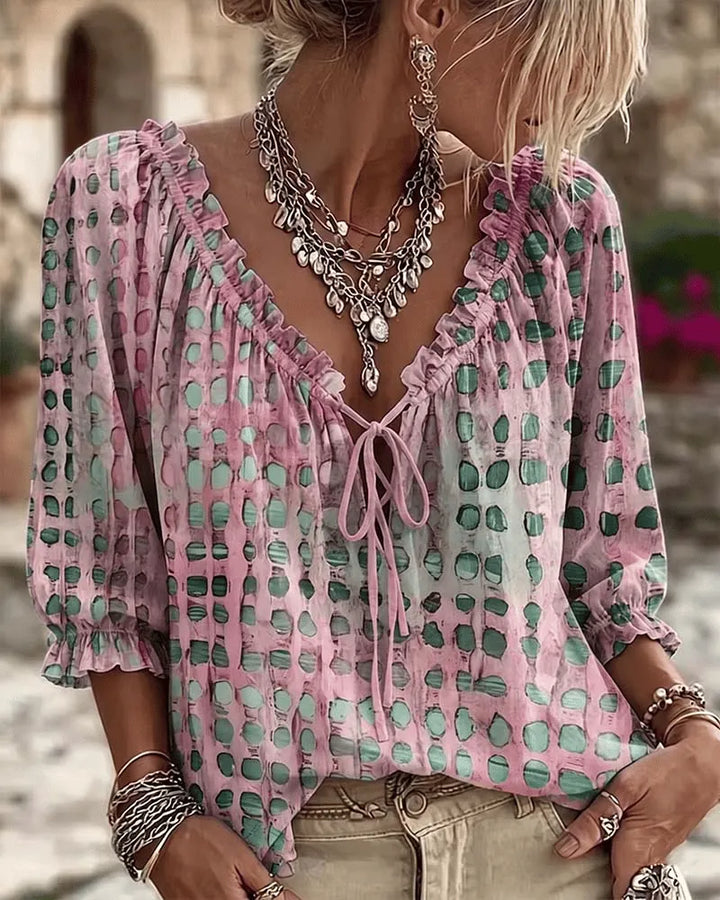 Woman wearing polka dot blouse with lace-up V-neck