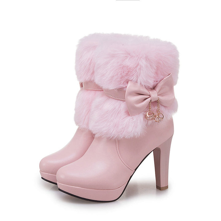 Woman wearing pink fur trim ankle boots with bow detail