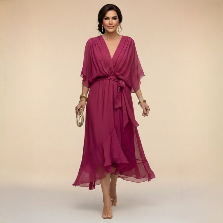 Woman wearing flowing V-neck dress in studio setting