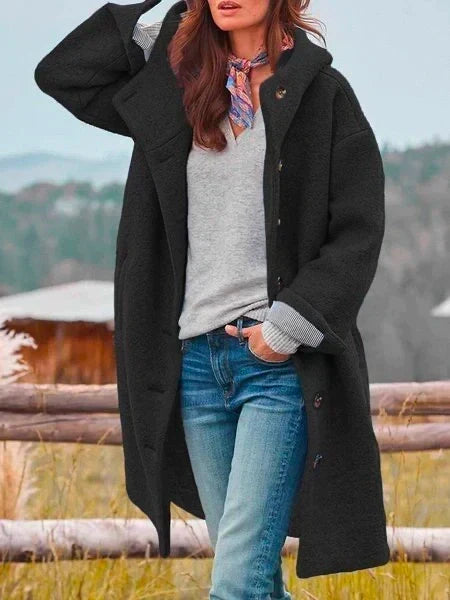 Woman wearing long hooded coat with button front