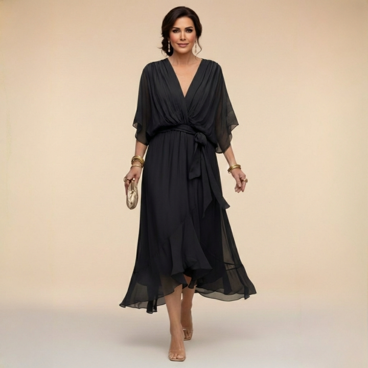 Woman wearing flowing V-neck dress in studio setting