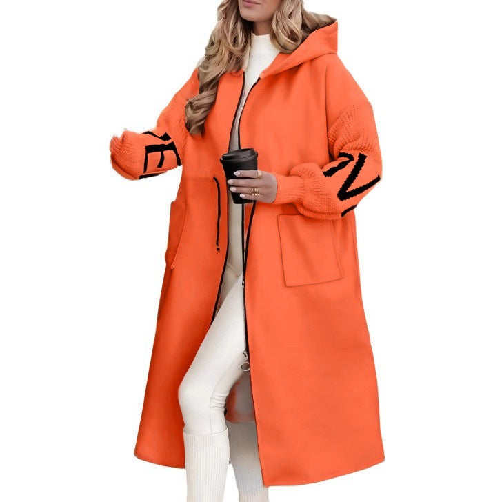 Woman wearing long hooded trench coat with drawstring detail