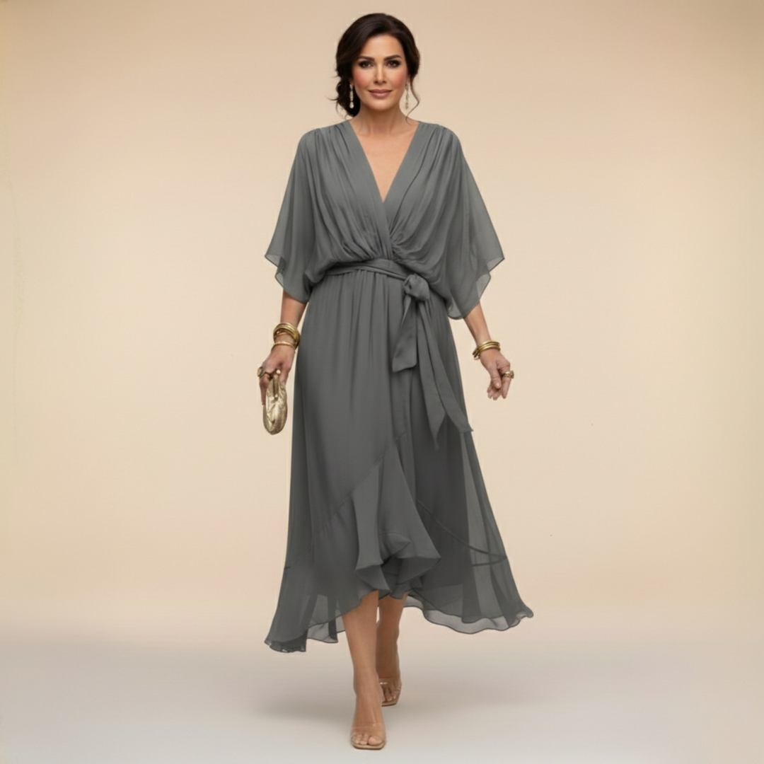 Woman wearing flowing V-neck dress in studio setting