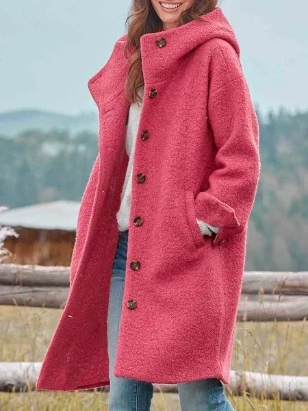 Woman wearing long hooded coat with button front