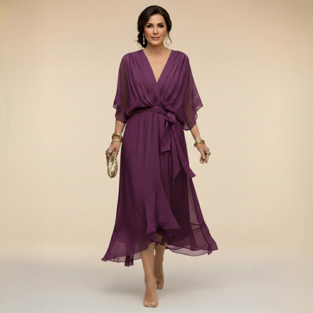 Woman wearing flowing V-neck dress in studio setting
