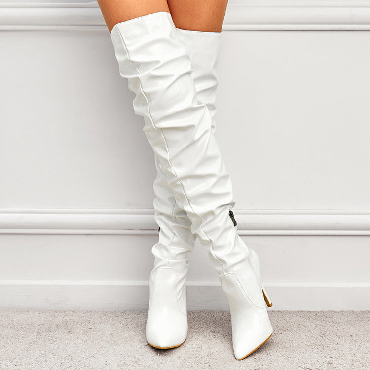 Woman wearing black knee high pointed toe heel boots