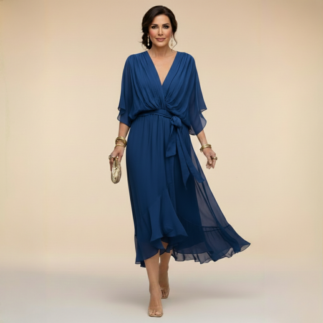Woman wearing flowing V-neck dress in studio setting