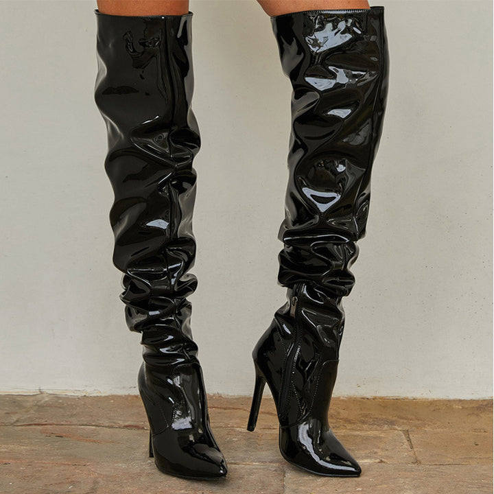 Woman wearing black knee high pointed toe heel boots