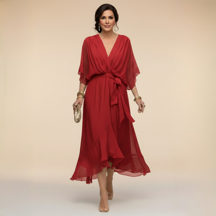 Woman wearing flowing V-neck dress in studio setting