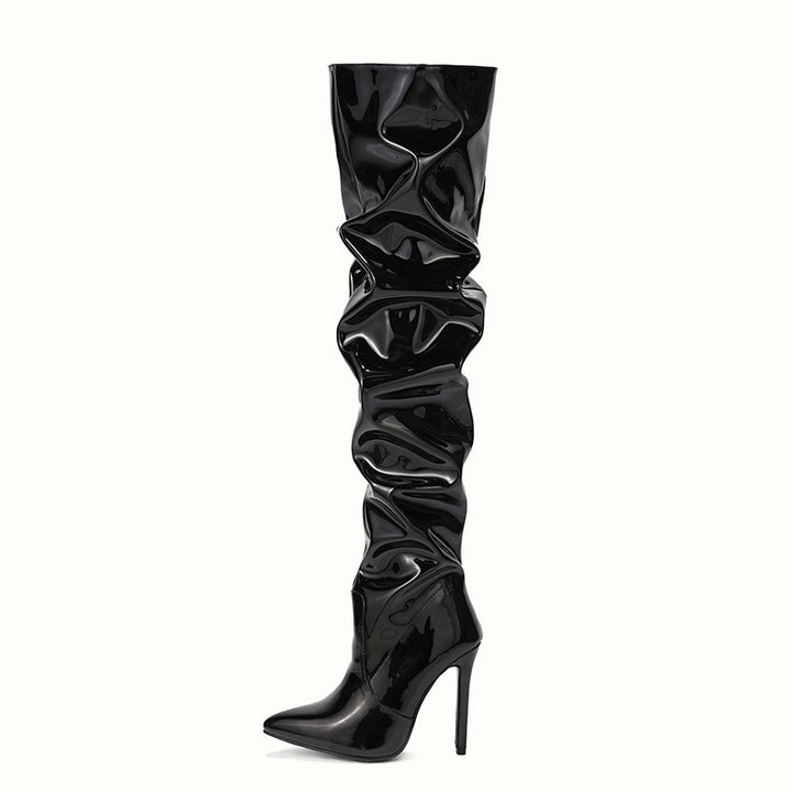 Woman wearing black knee high pointed toe heel boots