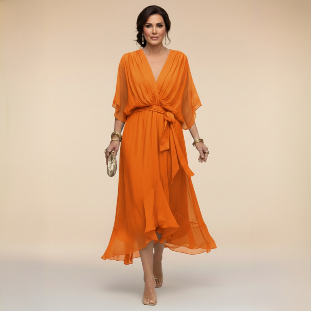 Woman wearing flowing V-neck dress in studio setting