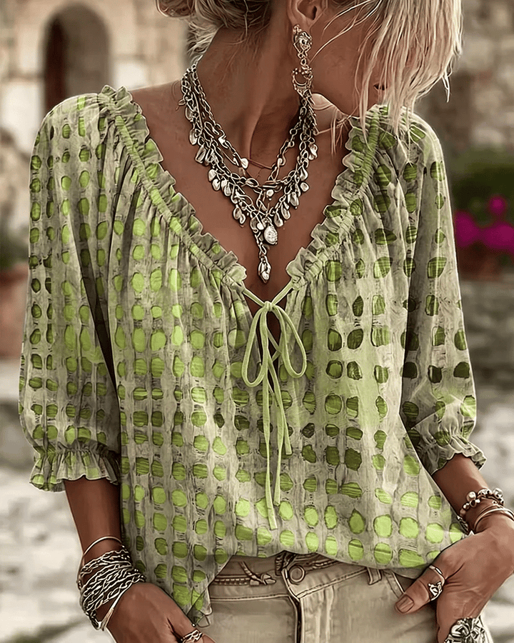 Woman wearing polka dot blouse with lace-up V-neck