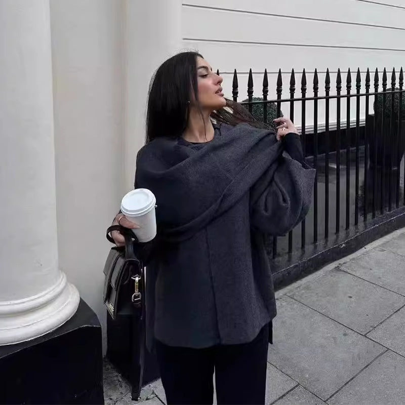 Woman wearing knit cardigan coat with asymmetric scarf detail
