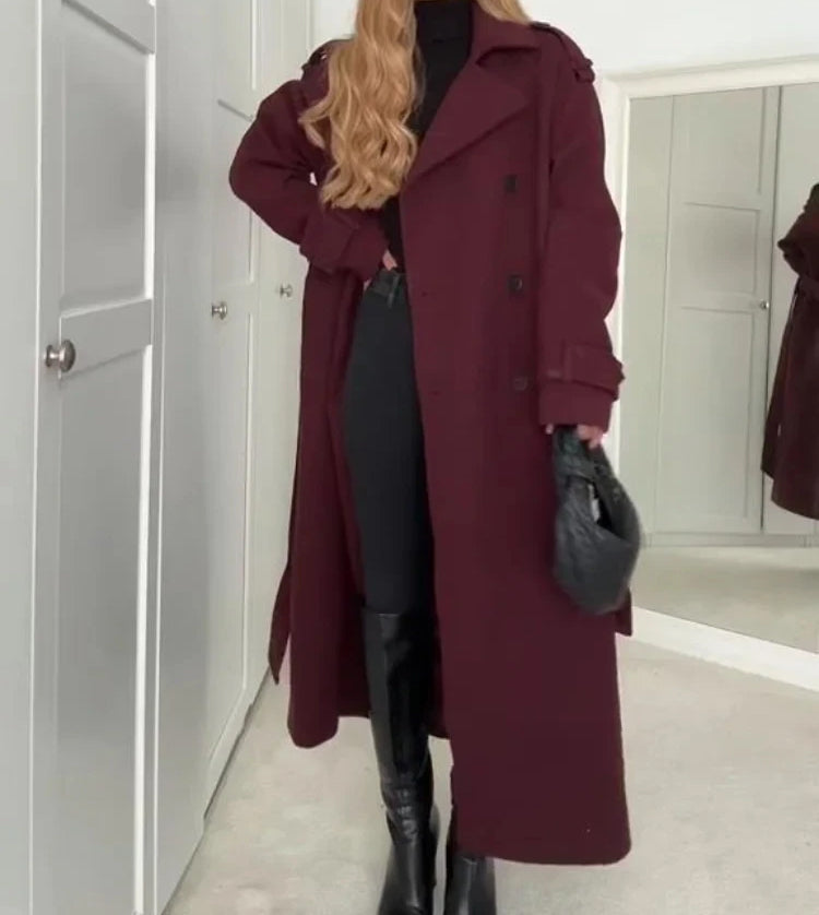 Woman wearing wine red long double-breasted trench coat with belt