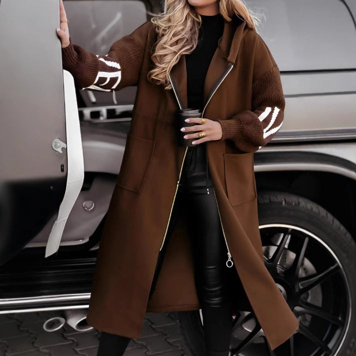 Woman wearing long hooded trench coat with drawstring detail