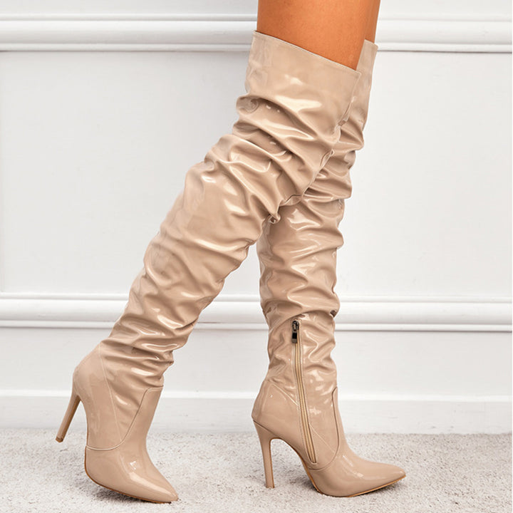 Woman wearing black knee high pointed toe heel boots