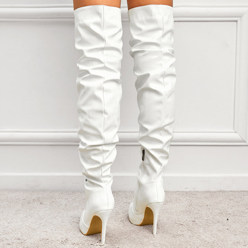 Woman wearing black knee high pointed toe heel boots