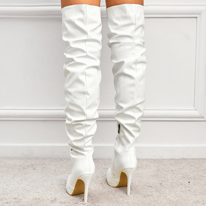 Woman wearing black knee high pointed toe heel boots