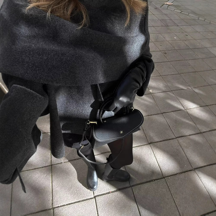 Woman wearing knit cardigan coat with asymmetric scarf detail