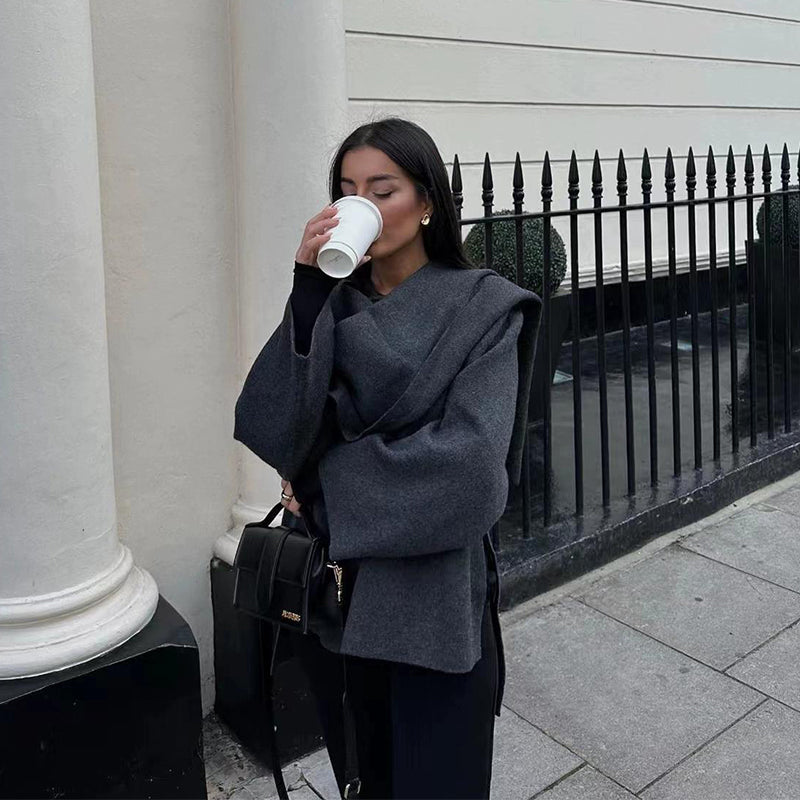 Woman wearing knit cardigan coat with asymmetric scarf detail
