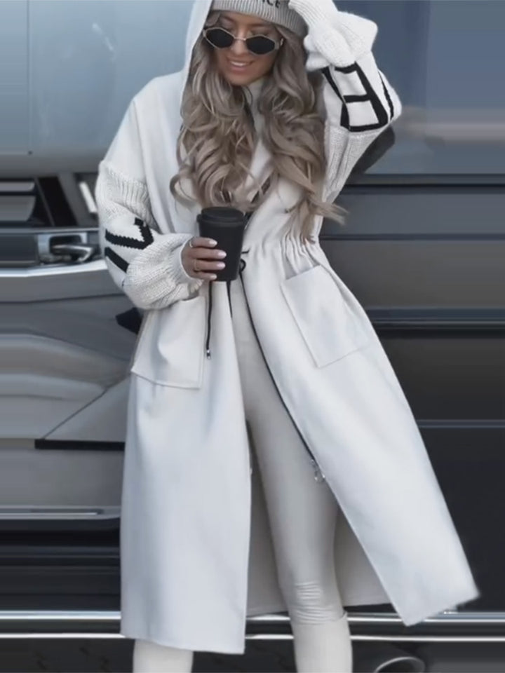Woman wearing long hooded trench coat with drawstring detail
